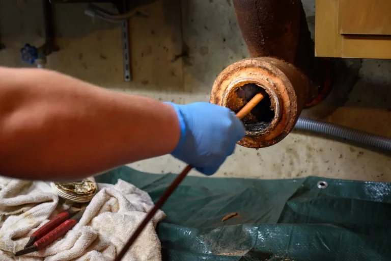 Water Heater Maintenance. Hands of a plumber as he runs a camera scope and cleaning machine through the main pipe