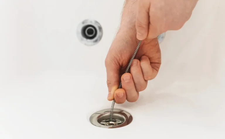 Durable Sump Pumps Plumber using drain snake to unclog bathtub